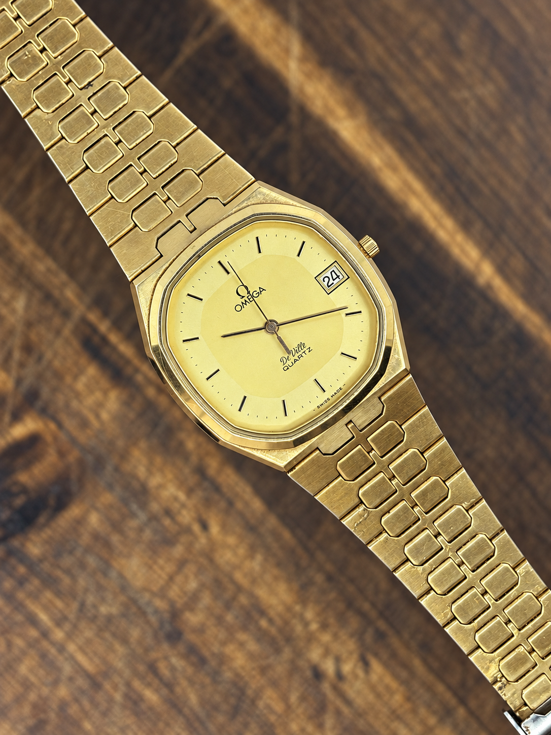 Vintage Omega De Ville Quartz watch with gold-tone octagonal case, champagne dial and integrated gold-tone bracelet
