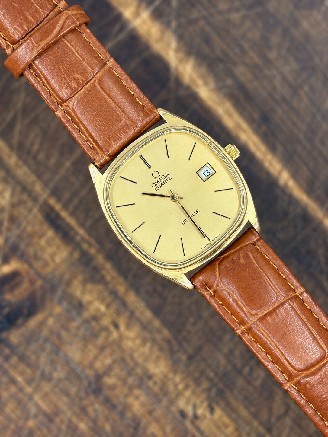 Vintage Omega De Ville Quartz watch with gold-tone cushion case, champagne dial and brown leather strap